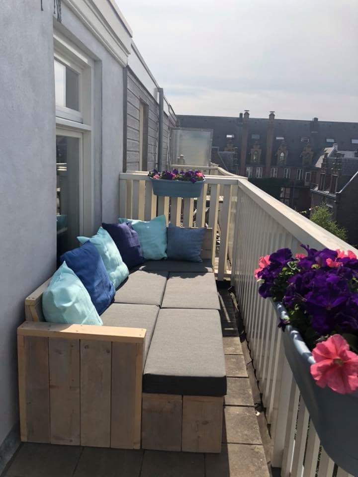 Bestaan Tablet minimum Balkon loungebank van gebruikt steigerhout op het balkon